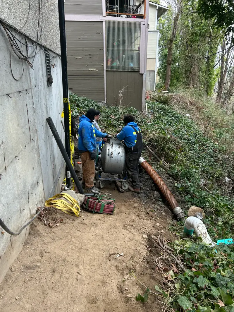 All Phase Plumbing crew clearing a main sewer line beside a hillside Seattle home